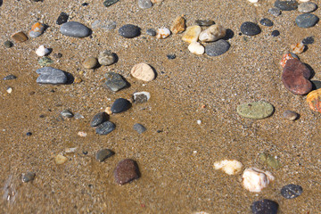 Fototapeta na wymiar Nasse Kieselsteine am Strand von Kreta im Sommer.