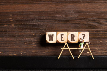 kleine Malerfigur und Würfel mit Wort 