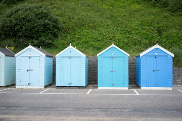Fototapeta na wymiar Colorful Beach huts, in blue colors, at the boulevard in Bournemouth, Dorset, UK, England on a cloudy day in summer