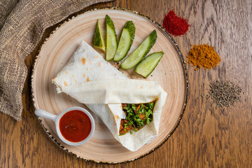 A cut kebab, shawarma, with grilled meal and vegetables