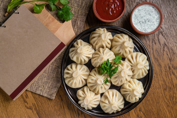 Georgian dumplings Khinkali with meat and red papper, on brown plate