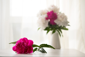 White and pink peonies in vase on white table