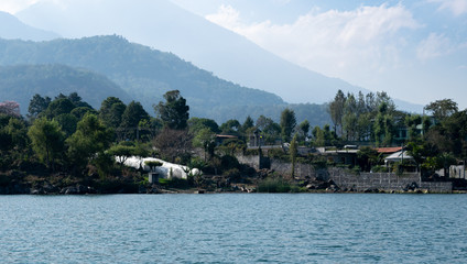 Fototapeta premium Shoreline with mountains behind at Lake Atitlan