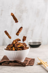 Fried eggplant in batter of soy sauce in a white plate closeup with copyspace. Asian food in flight.
