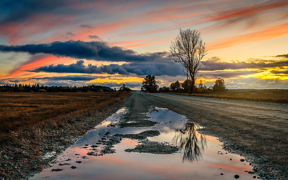 sunset o the road ith pudle