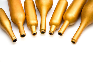 Bottles of different sizes in gold color isolated on a white background.