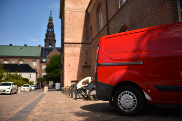 Fototapeta na wymiar red commercial van in old european city