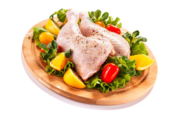 Raw chicken thighs and vegetables on white background 