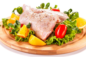 Raw chicken thighs and vegetables on white background 