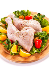 Raw chicken thighs and vegetables on white background 