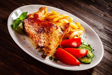 Roast chicken leg with french fries and vegetable salad 