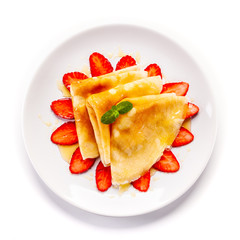 Tasty crepes with strawberries on white background