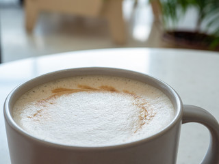 cup of coffee latte  on a white table. Foam. close-up. bokeh