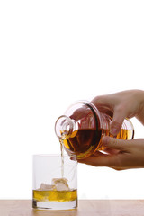 whiskey on the rocks - being poured into a glass from a whiskey decanter
