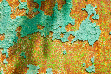 Textured metal surface covered with old peeling paint and rust.