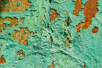 Textured metal surface covered with old peeling paint and rust.