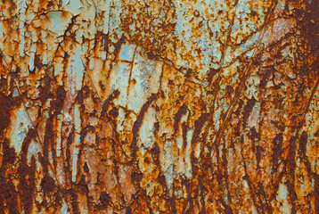Textured metal surface covered with old paint and rust.