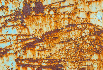 Textured metal surface covered with old peeling paint and rust.