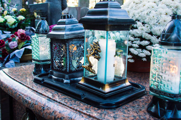 Monument and candles in the cemetery. All Saints Day in Poland. Lamp in the cemetery.	