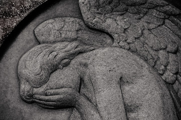 Monument and candles in the cemetery. All Saints Day in Poland. Stone sculpture. Stone angel....
