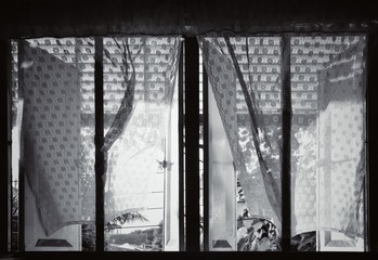 The sunlight penetrates through the curtains and the lace on the window