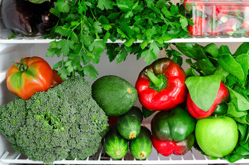 Greens, fruits and vegetables in fridge. Vegan, raw, healthy lifestyle concept
