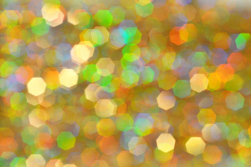 Glowing and festive colored light circles created from in camera and lens bokeh. Christmas fairy lights defocused giving a blurred effect. Background for design.