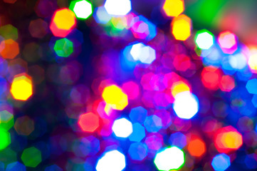 Glowing and festive colored light circles created from in camera and lens bokeh. Christmas fairy lights defocused giving a blurred effect. Background for design.