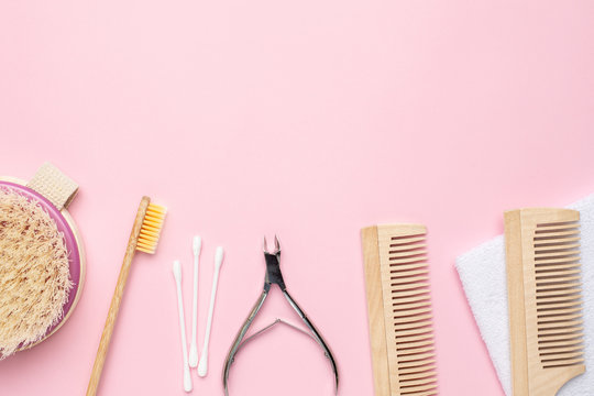 Pink background with wooden toothbrush , comb and nippers , bathroom and spa accessory copyspace
