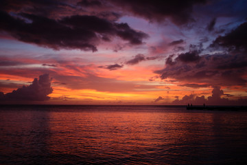 Fototapeta na wymiar Coucher de soleil couleur feu sur la mer en Martinique
