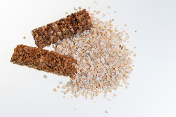 Диетические батончики и овсяные хлопья на белом фоне