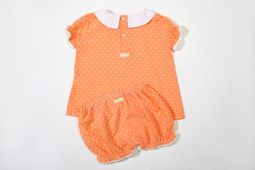 orange baby pajamas. Sleeping outfit for baby girl. On white background, close-up shot and top view