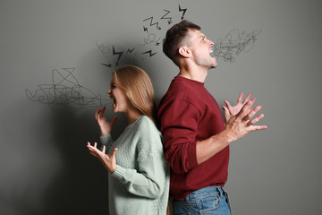 Portrait of angry couple on grey background