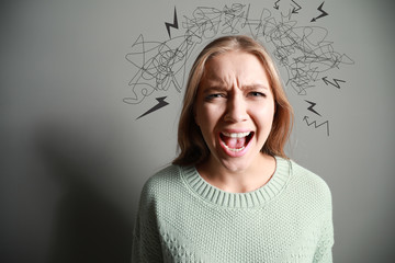 Portrait of angry woman on grey background