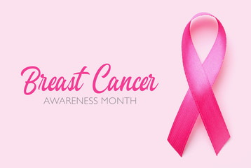 Pink ribbon and text BREAST CANCER AWARENESS MONTH on color background