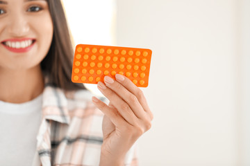 Young woman with pills at home