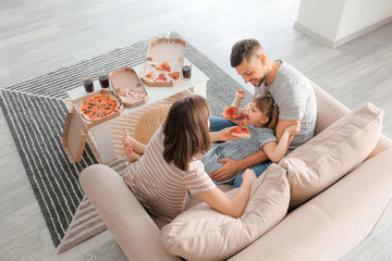 Happy family eating pizza at home