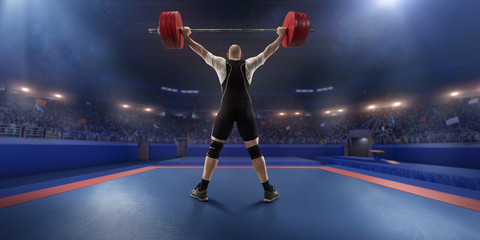 Fototapeta na wymiar Male athlete is lifting a barbell on a professional stadium. Stadium and crowd are made in 3d.