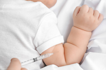 Nurse vaccinating little baby in clinic, closeup