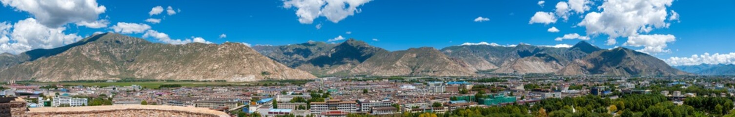 Large panorama of Lhasa, capital of Tibet, China, from the Potala Palace, former residence of the Dalai Lama, with the Himalayas mountains in the background - obrazy, fototapety, plakaty