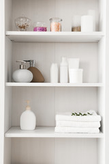 Fototapeta na wymiar Shelf unit with towels and cosmetics
