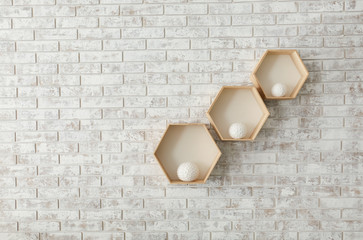 Shelves with decor hanging on brick wall