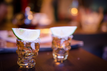 Two shots with lime on bar counter