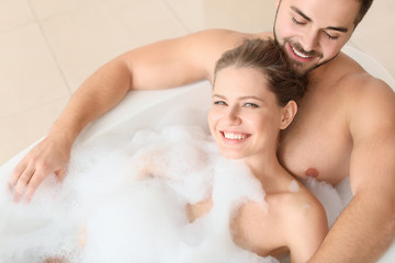 Happy young couple taking bath together