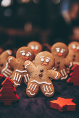 Many Christmas cookies in the form of gingerbread men depicting people celebrating the New Year in the forest near the Christmas tree