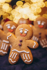 Many Christmas cookies in the form of gingerbread men depicting people celebrating the New Year in the forest near the Christmas tree