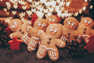 Many Christmas cookies in the form of gingerbread men depicting people celebrating the New Year in the forest near the Christmas tree