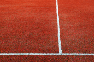Fototapeta premium Part of empty used red tennis court playground surface with white lines closeup