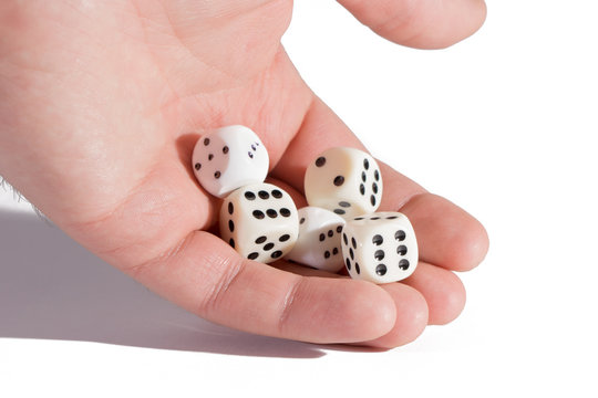 Man's hand holding playing dices. Isolated on white. Close-up of a human hand holding five dice