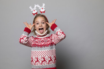 Funny kid with Christmas band. Cheerful smiling little girl .